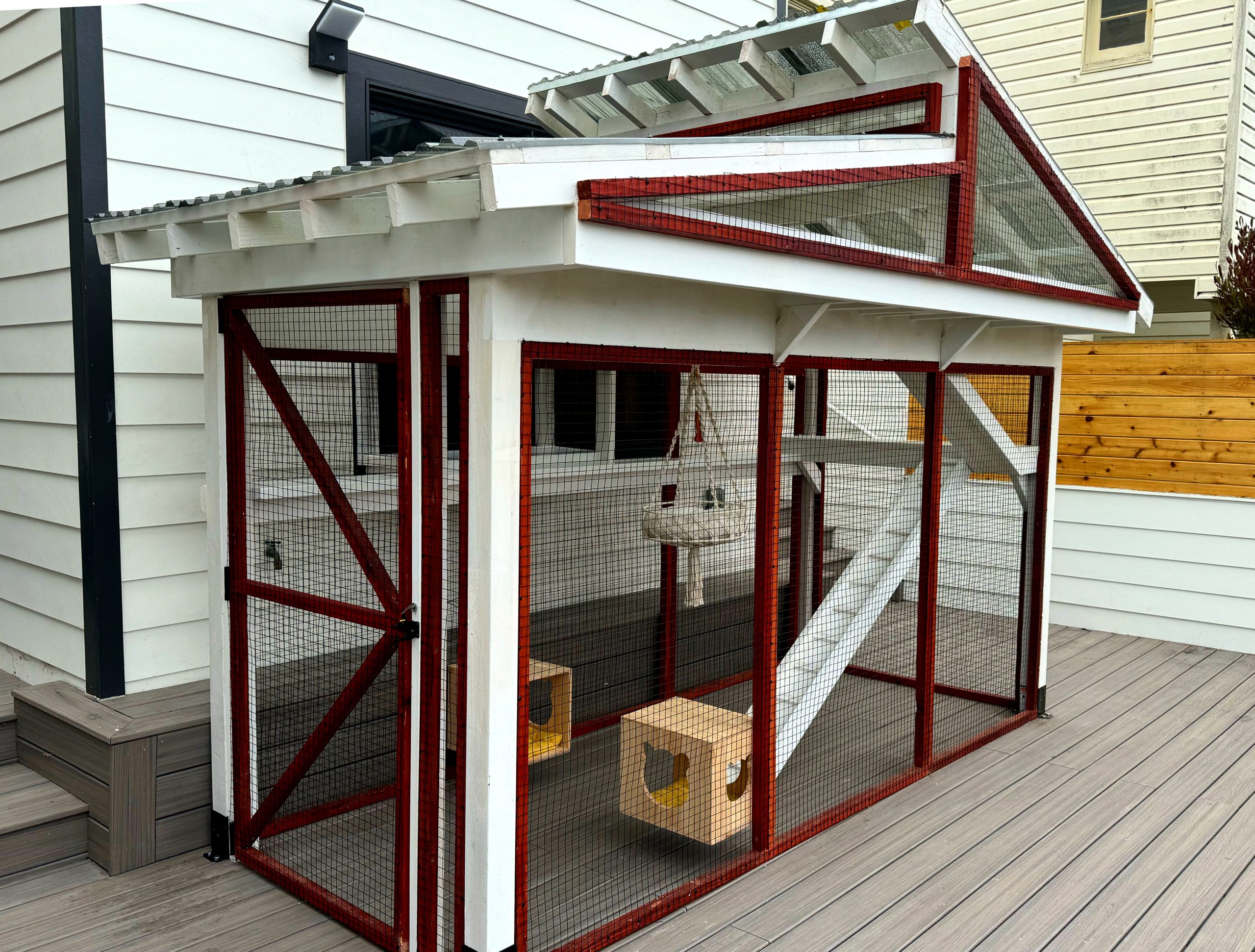 Stylish redwood-stained and white-painted catio with toys and ramps